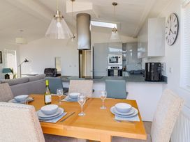 A dining room with a table set for a meal at Cedar 1 in Pinewood Retreat in Rousdon near Lyme Regis