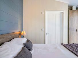 A bedroom with a bed and lamp at Cedar 1 in Pinewood Retreat in Rousdon near Lyme Regis