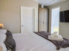 A bedroom with a bed and a window at Cedar 1 Pinewood Retreat in Rousdon near Lyme Regis