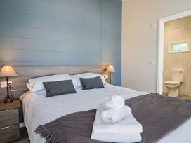 A bedroom with bed and adjoining toilet at Cedar 1 Pinewood Retreat in Rousdon near Lyme Regis