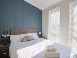 A bedroom with a bed and pillows at Cedar 1 Pinewood Retreat in Rousdon near Lyme Regis