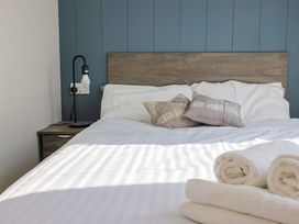 A bedroom with a bed and pillows at Cedar 1 Pinewood Retreat in Rousdon near Lyme Regis