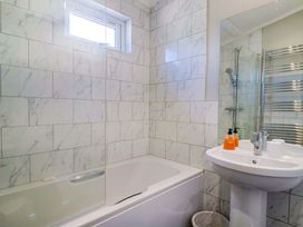 A bathroom with a bathtub, sink, and shower at Cedar 1 in Pinewood Retreat in Rousdon near Lyme Regis