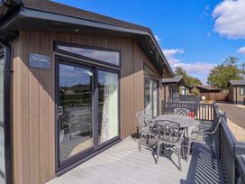 A deck with a table and chairs at Cedar 1 in Pinewood Retreat in Rousdon near Lyme Regis