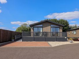 A cabin with a deck and driveway at Cedar 1 Pinewood Retreat in Rousdon near Lyme Regis