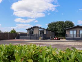 Two holiday lodges with decking and plants at Cedar 1 at Pinewood Retreat in Rousdon near Lyme Regis