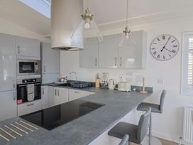 A kitchen with bar counter and appliances at Cedar 1 in Pinewood Retreat in Rousdon near Lyme Regis