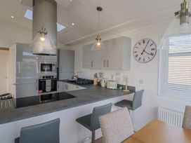 A kitchen with appliances and seating at Cedar 1 Pinewood Retreat in Rousdon near Lyme Regis