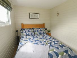 A bedroom with a double bed and bedside table at Llewelyn in Ty Croes
