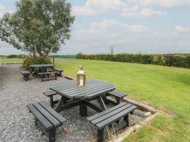 A picnic area with tables and a lantern at Llewelyn in Ty Croes