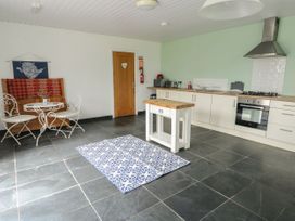 A kitchen with a dining area and appliances at Llewelyn in Ty Croes