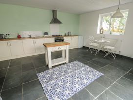A kitchen with an island and dining area at Llewelyn in Ty Croes