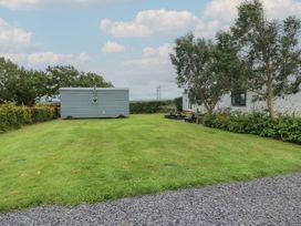 A garden area with grass and trees at Llewelyn Ty Croes