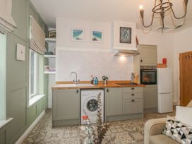A kitchen with a washing machine, sink, and wooden countertop at Apartment 2 The Bridge at Stanford Hotel near Great Witley