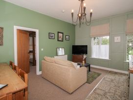 A living room with a sofa and television at Apartment 2 The Bridge at Stanford Hotel near Great Witley