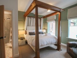 A bedroom with a canopy bed and a shower area at Apartment 2 The Bridge at Stanford Hotel near Great Witley