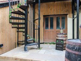 An outdoor area with a spiral staircase and a welcome sign at Apartment 2 The Bridge at Stanford Hotel near Great Witley