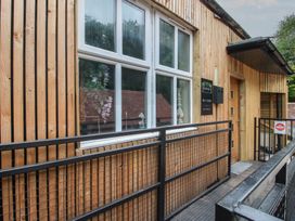 An entrance with wooden walls and a sign at Apartment 2 The Bridge at Stanford Hotel near Great Witley