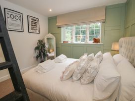 A bedroom with a bed, pillows, a lamp, and a mirror at Apartment 1 The Bridge at Stanford Hotel near Great Witley