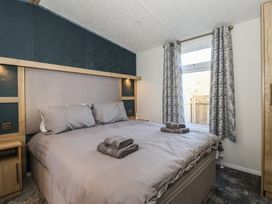 A bedroom with a bed and window at Meadows Park 2 Great Hatfield near Hornsea