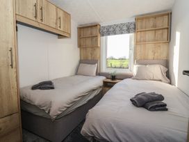A bedroom with two single beds and storage at Meadows Park 2 Great Hatfield near Hornsea