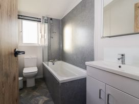 A bathroom with a bathtub and sink at Meadows Park 2 in Great Hatfield near Hornsea