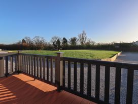 An outdoor area with a deck overlooking a grassy space at Meadows Park 3 Great Hatfield near Hornsea