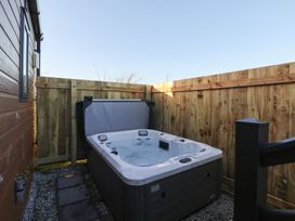 A hot tub surrounded by a wooden fence at Meadows Park 4 Great Hatfield near Hornsea