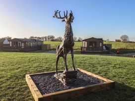 A deer statue with lodges in the background at Meadows Park 4 Great Hatfield near Hornsea