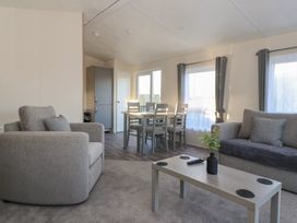 A living room with a dining area and furniture at Meadows Park 5 in Great Hatfield near Hornsea