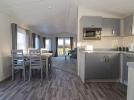 A living room with a dining area and kitchen cabinets at Meadows Park 5 Great Hatfield near Hornsea