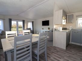 A living room with a dining table and kitchen area at Meadows Park 5 Great Hatfield near Hornsea