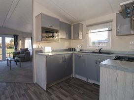 A kitchen with cabinets and appliances at Meadows Park 5 in Great Hatfield near Hornsea