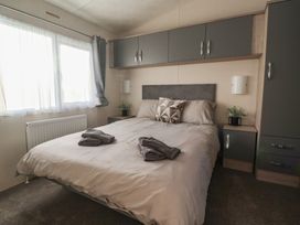 A bedroom with a bed and storage in Meadows Park 5 Great Hatfield near Hornsea