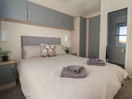 A bedroom with a bed and cupboards at Meadows Park 5 Great Hatfield near Hornsea