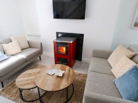 A living room with a stove and two sofas at Rose Cottage in Killala, County Mayo