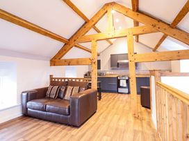A loft with a sofa and kitchen units at Clegir Bach Corwen