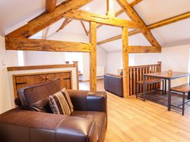 A living room with a sofa and table at Clegir Bach in Corwen
