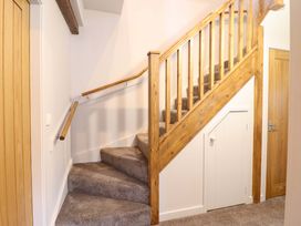 A staircase with wooden railings and carpet at Clegir Bach in Corwen