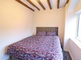 A bedroom with a bed and window at Clegir Bach in Corwen