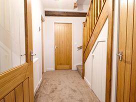 A hallway with staircase and wooden doors at Clegir Bach Corwen