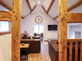 A living room with a television and wooden beams at Clegir Bach near Betws Gwerfil Goch