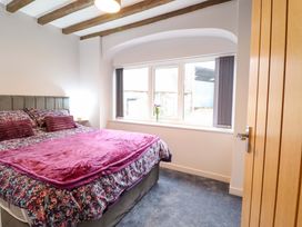A bedroom with a bed and window at Clegir Bach Betws Gwerfil Goch near Corwen