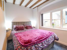 A bedroom with a bed and window at Clegir Bach near Betws Gwerfil Goch