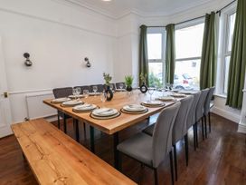 A dining room with a large table set for dinner at Mariners Lee