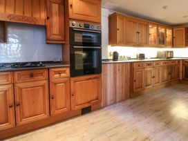 A kitchen with wooden cabinets and appliances at Mariners Lee