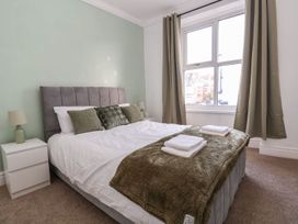 A bedroom with a bed and bedside table at Mariners Lee