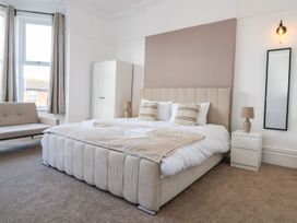 A bedroom with a large bed and a sofa at Mariners Lee