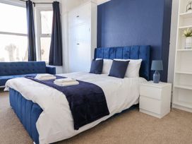 A bedroom with a bed and sofa at Mariners Lee