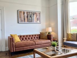 A living room with a sofa and a table at Clarence House in Llandudno